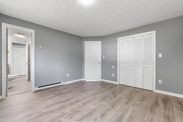 a view of an empty room with wooden floor