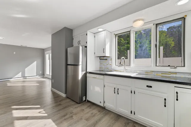 a kitchen with granite countertop a refrigerator and a sink