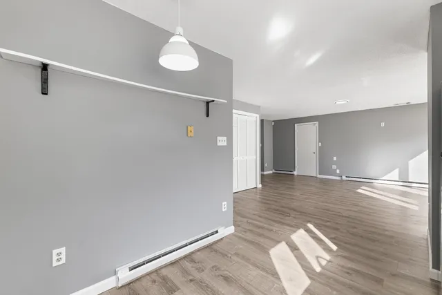 a view of an empty room with wooden floor