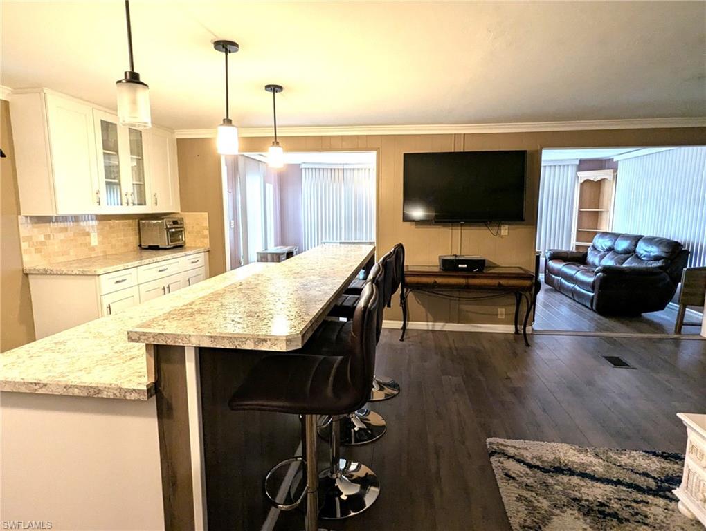 9269 Lord Road Bonita Springs, FL 34135 - Photo 6 of 20 a living room with stainless steel appliances kitchen island granite countertop furniture and a flat screen tv