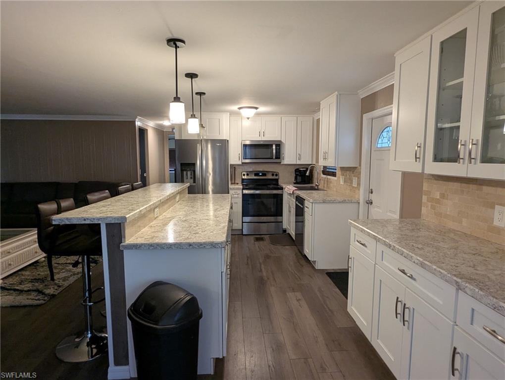9269 Lord Road Bonita Springs, FL 34135 - Photo 7 of 20 a large kitchen with granite countertop a stove top oven a sink a counter space and cabinets