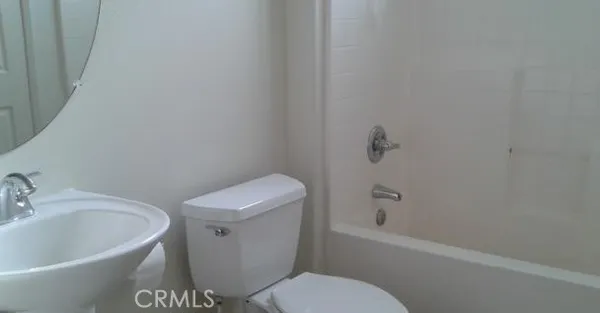 a white toilet sitting next to a bath tub