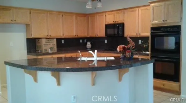 a kitchen with a sink a microwave and cabinets