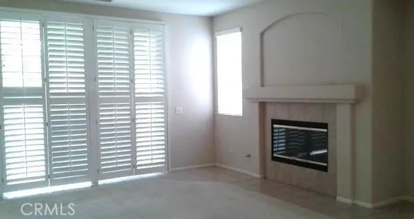 a view of an empty room with a fireplace and a window