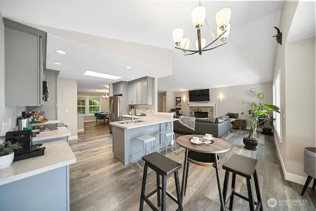 a kitchen with a dining table chairs stainless steel appliances and cabinets