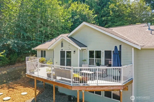 a view of a house with a wooden deck and furniture