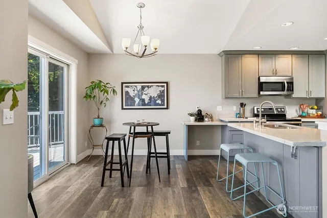 a view of a dining room with furniture a chandelier and wooden floor