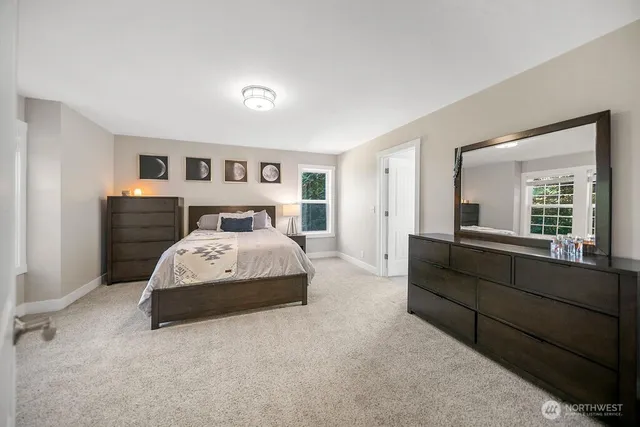 a bedroom with a bed and a large mirror