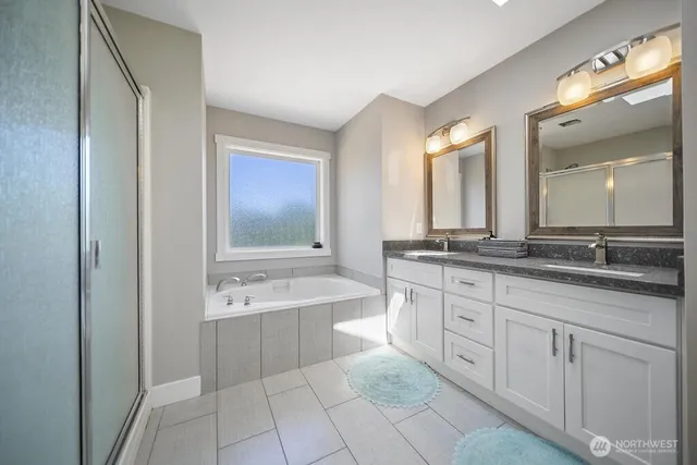 a spacious bathroom with a double vanity sink mirror and a bathtub