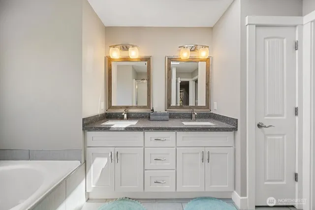 a bathroom with a double vanity sink and a mirror