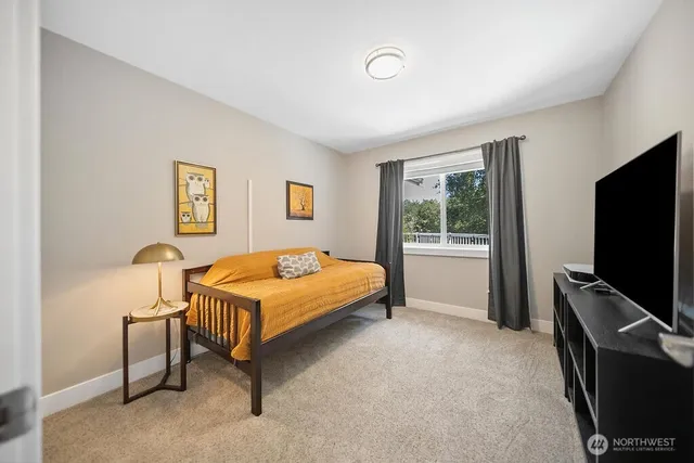 a bedroom with a bed tv and a window