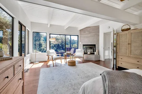a living room with furniture large window and wooden floor