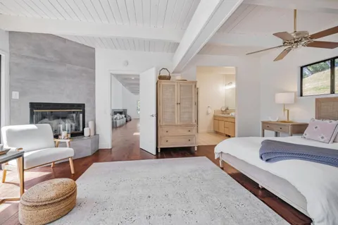 a spacious bedroom with a bed a couch and a chandelier