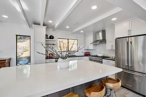 a kitchen with a sink a stove and chairs