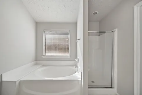 a bathroom with a tub sink and mirror
