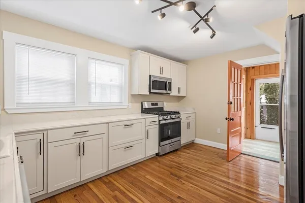 a kitchen with white cabinets and appliances