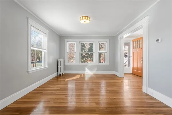 a view of empty room with wooden floor and fan