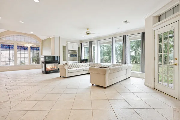 a living room with couches and a dining table with a large window