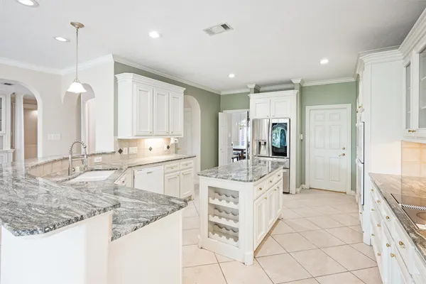 a large white kitchen with a sink and dishwasher