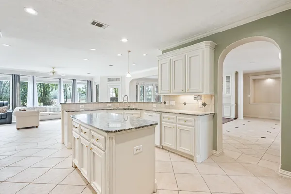 a kitchen with granite countertop a sink and white cabinets