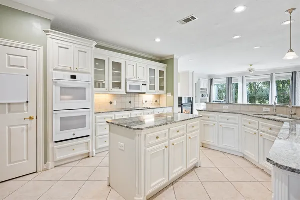 a kitchen with granite countertop white cabinets and white appliances