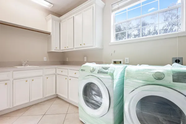 a utility room with sink dryer and washer
