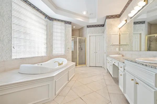 a spacious bathroom with a granite countertop sink a bathtub and a shower