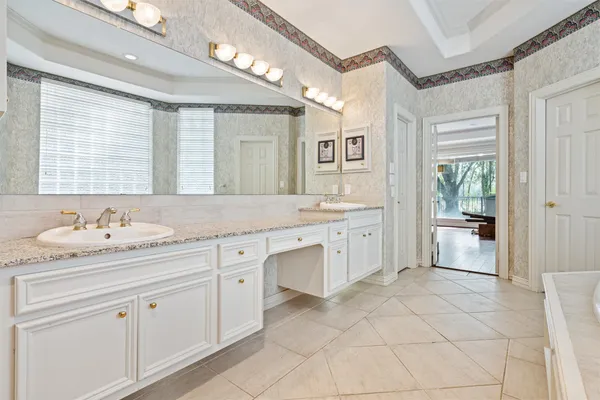 a spacious bathroom with a granite countertop sink mirror and a