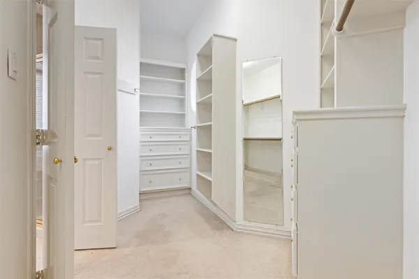 a view of walk in closet with empty racks