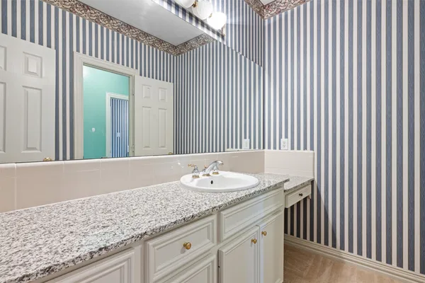 a bathroom with a granite countertop sink and a mirror