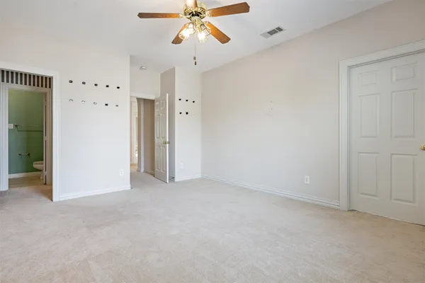 an empty room with closet and a chandelier fan