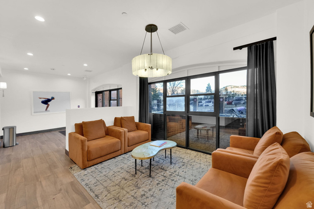50 Shadow Ridge Road, Unit 4209 Park City, UT 84060 - Photo 25 of 50 Spacious room featuring wood-finish flooring, a contemporary chandelier, recessed lighting, and large windows with dark drapery
