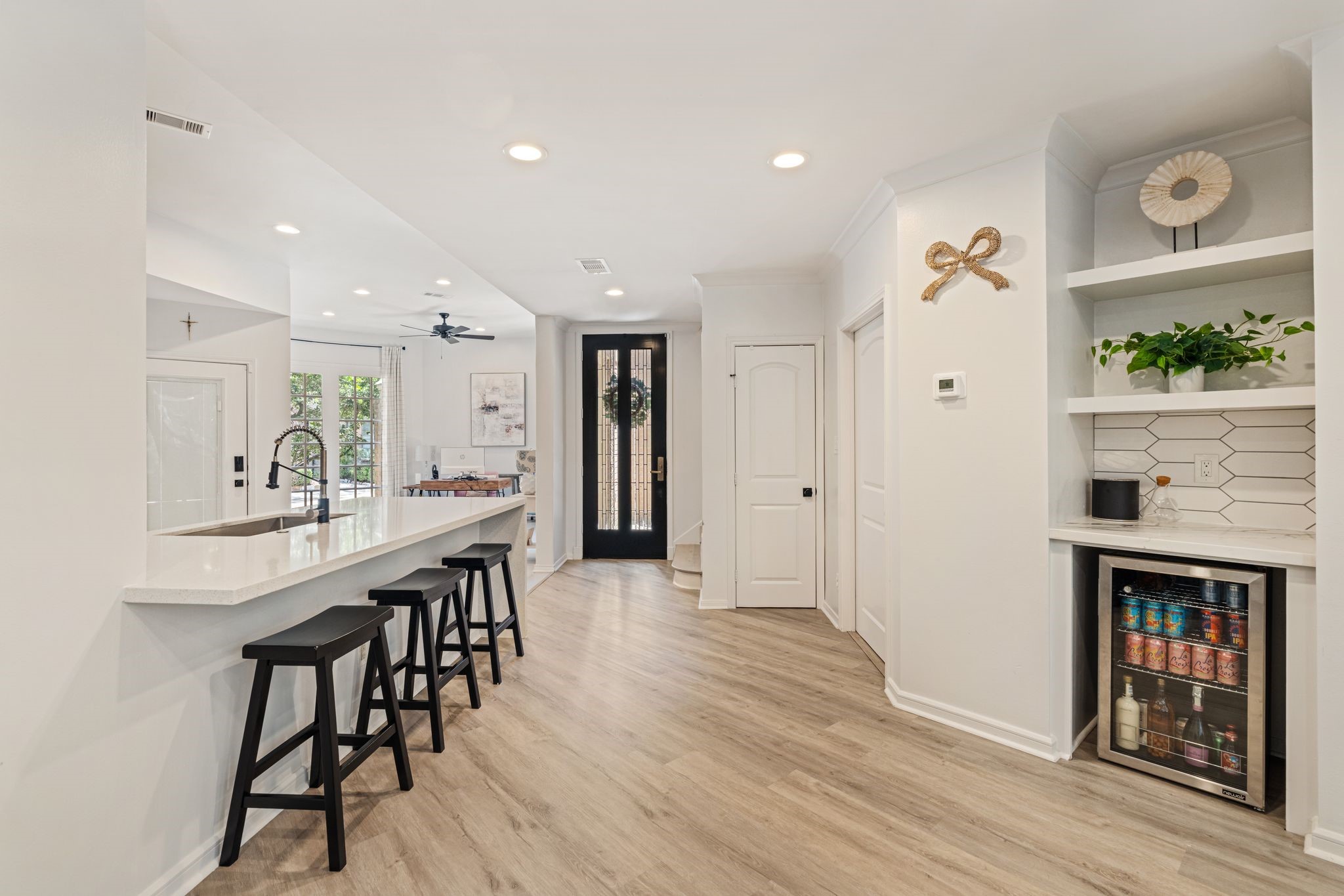 201 Vanderpool Lane, Unit 137 Houston, TX 77024 - Photo 8 of 42 A built-in bar with a beverage fridge, open display shelves, and tile backsplash adds a thoughtful entertaining feature just off of the kitchen.