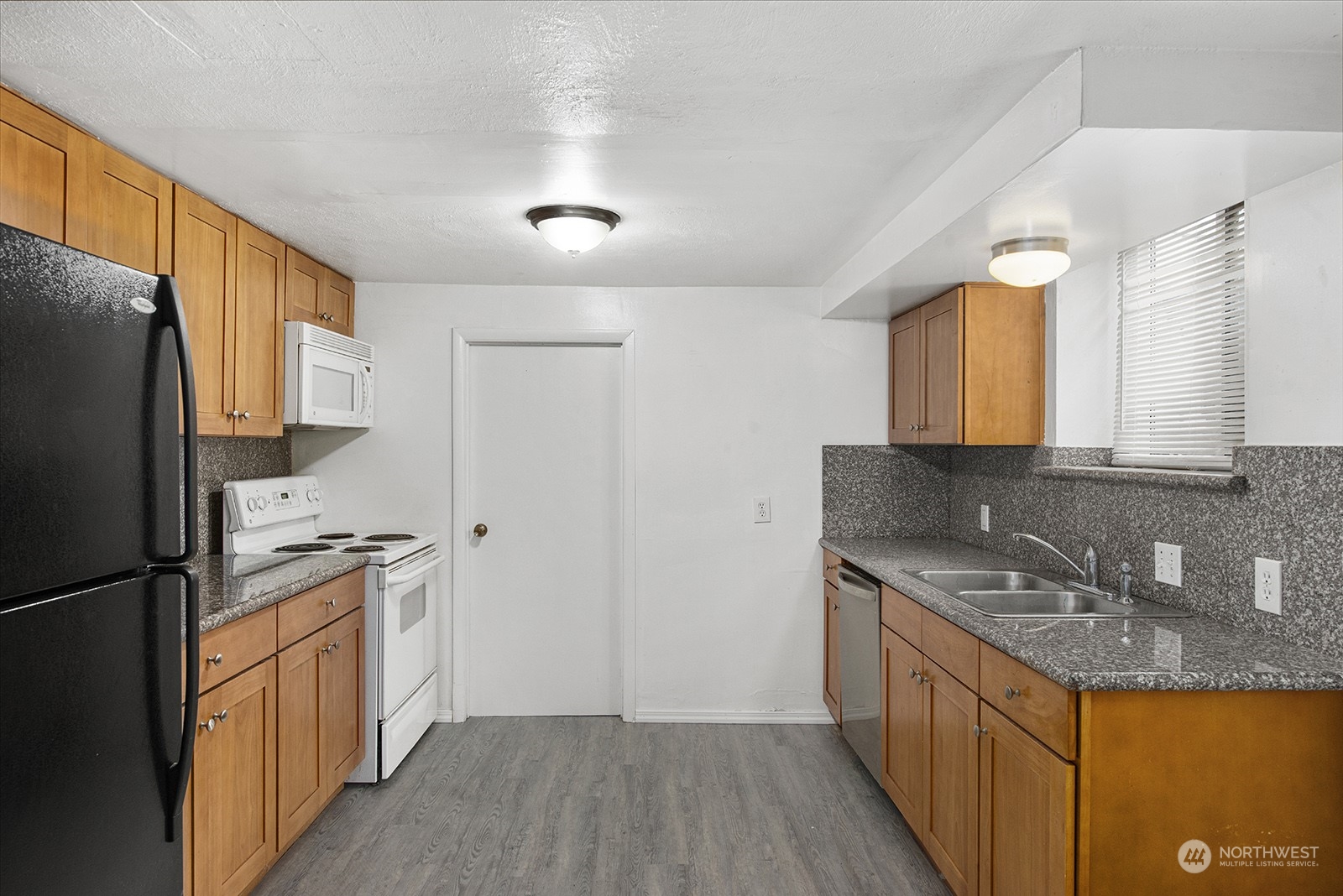 260 Taylor Avenue Northwest Renton, WA 98057 - Photo 16 of 26 a kitchen with stainless steel appliances granite countertop a refrigerator a stove a sink and a refrigerator with wooden floor