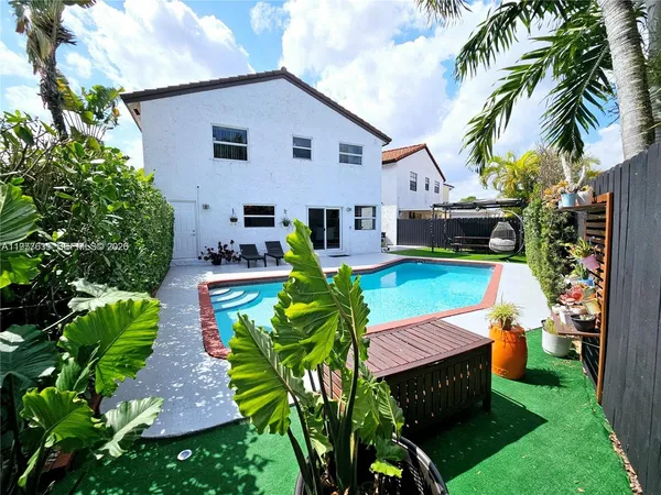 a view of a house with backyard sitting area and swimming pool