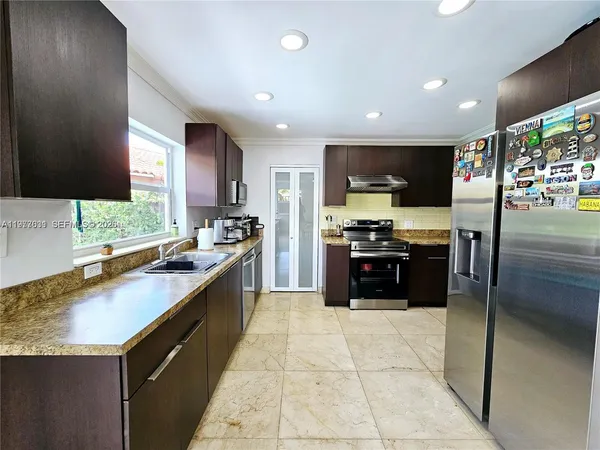 a kitchen with stainless steel appliances granite countertop a sink and a stove