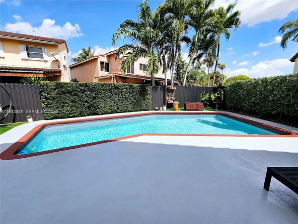 a view of a chair and table in backyard of the house