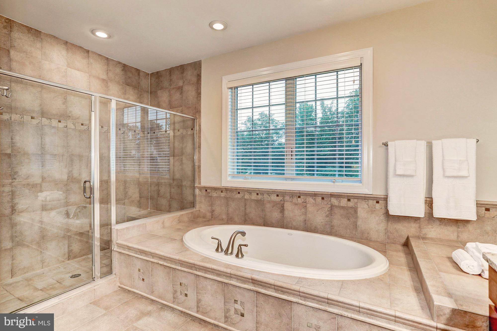 7111 Granberry Way Springfield, VA 22151 - Photo 19 of 30 a bathroom with a bathtub and a shower