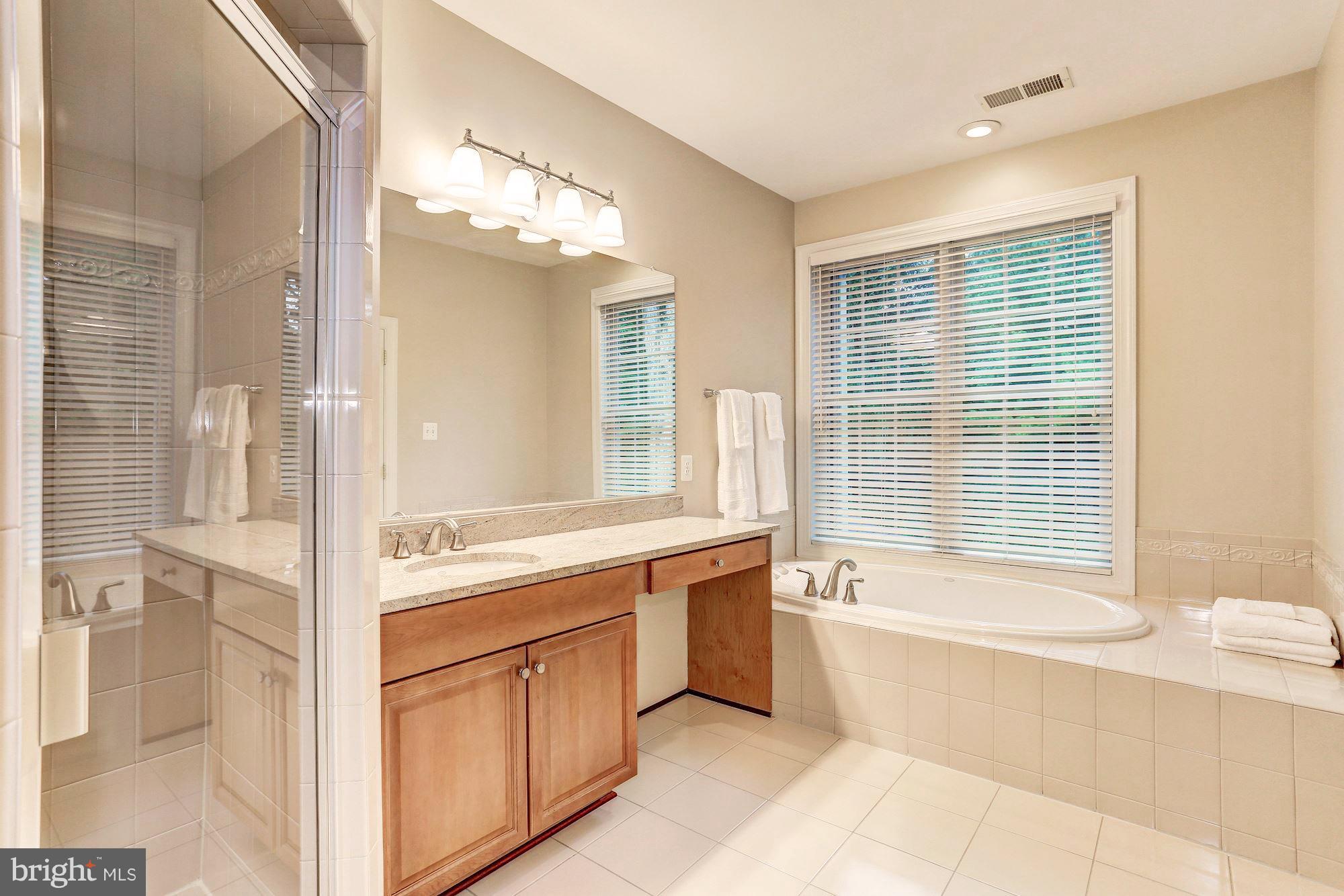 7111 Granberry Way Springfield, VA 22151 - Photo 23 of 30 a spacious bathroom with a tub sink shower and mirror