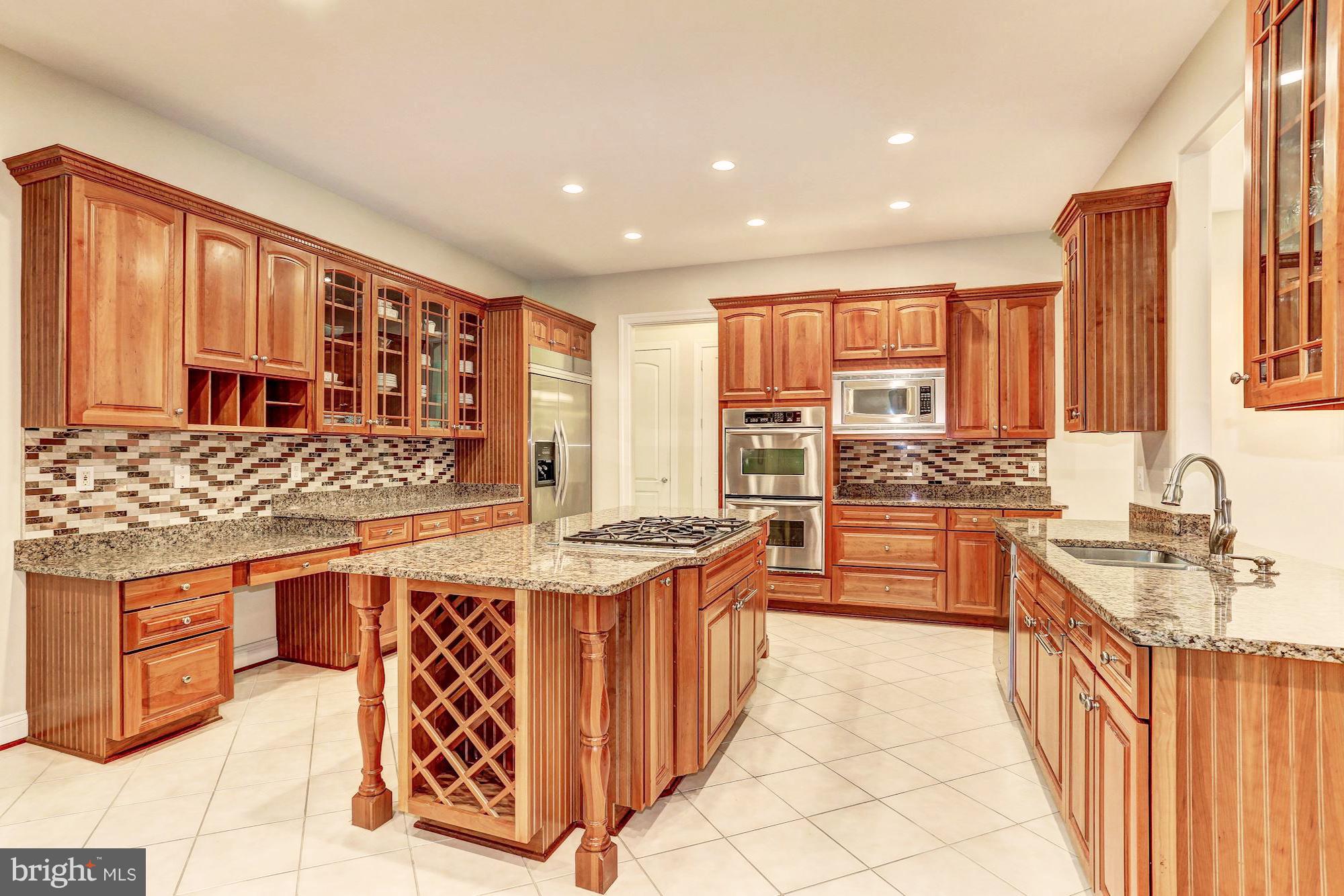 7111 Granberry Way Springfield, VA 22151 - Photo 5 of 30 a kitchen with stainless steel appliances kitchen island granite countertop a stove a sink and a refrigerator