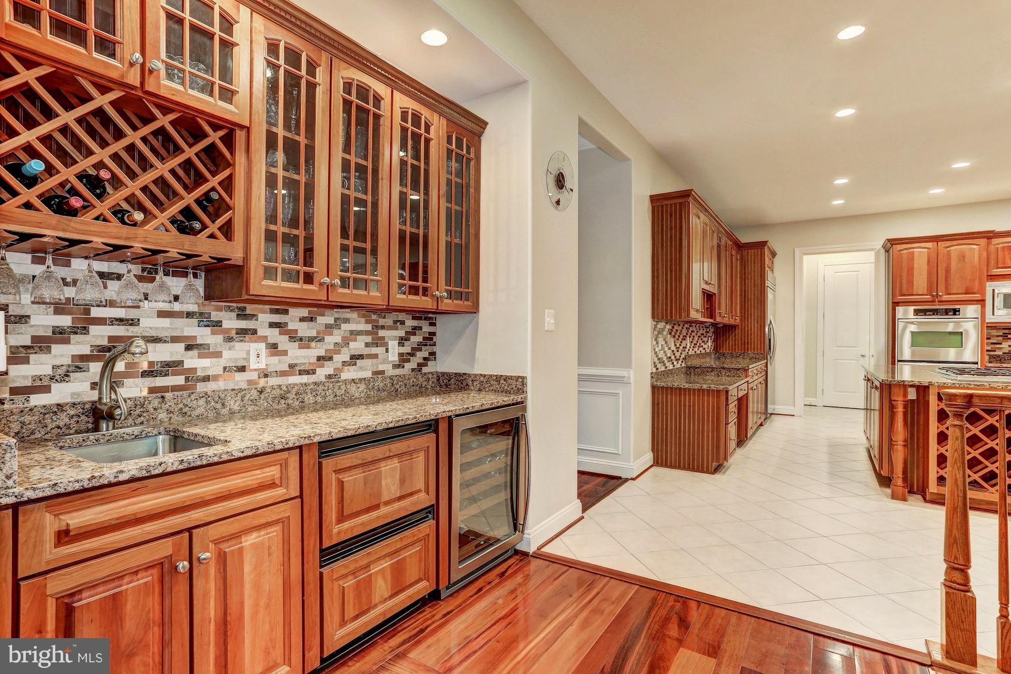 7111 Granberry Way Springfield, VA 22151 - Photo 6 of 30 a kitchen with granite countertop wooden cabinets and stainless steel appliances