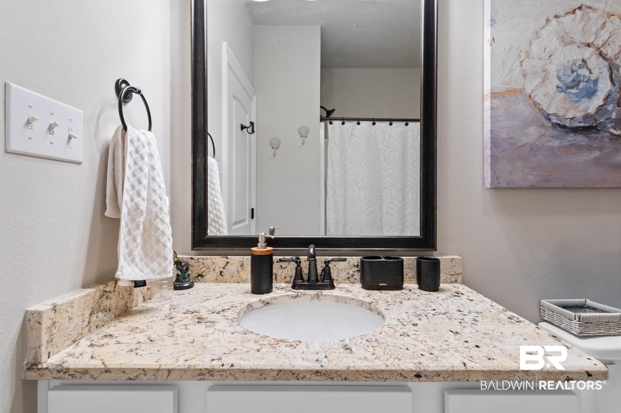 22244 Hibiscus Circle Foley, AL 36535 - Photo 49 of 51 Vanity featuring a polished stone countertop with an integrated sink and dark bronze faucet