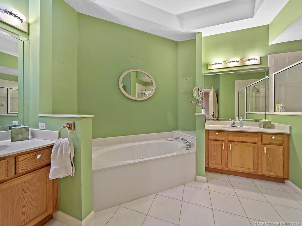 570 Northwest Red Pine Way Jensen Beach, FL 34957 - Photo 11 of 19 a bathroom with a sink a bathtub and a mirror