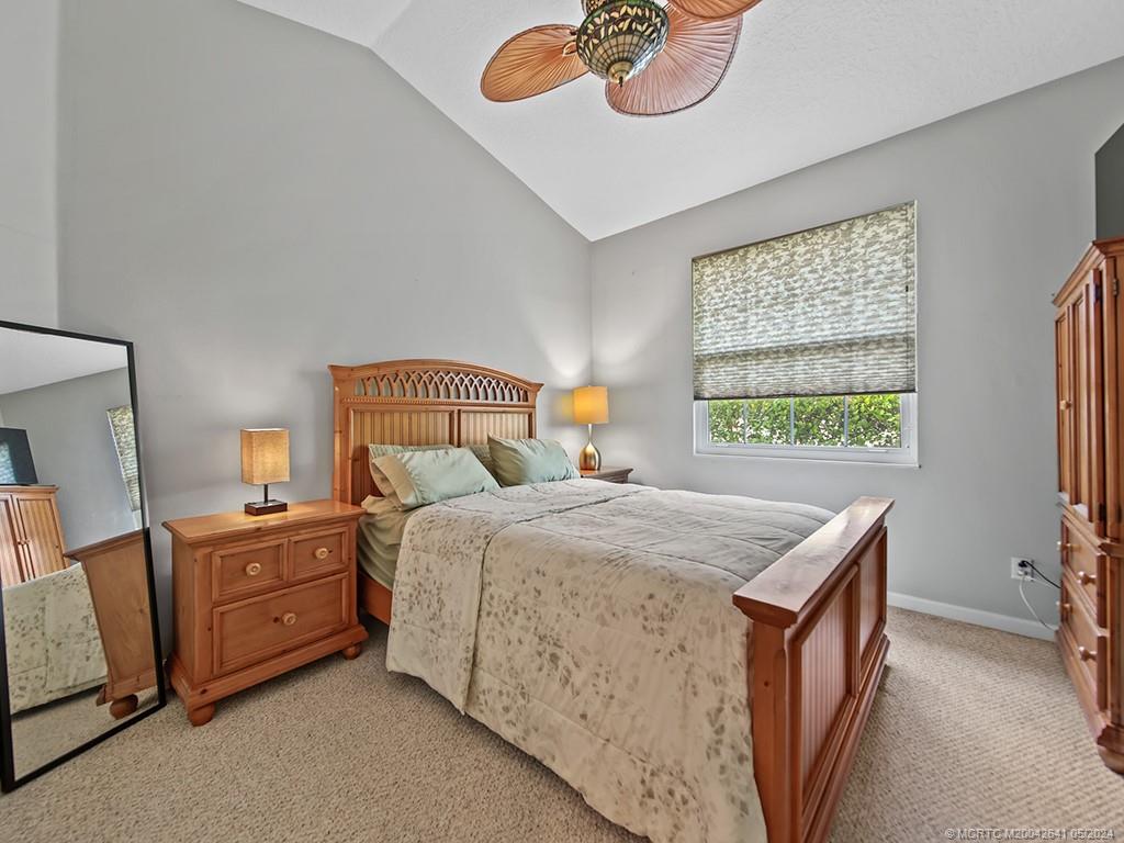 570 Northwest Red Pine Way Jensen Beach, FL 34957 - Photo 14 of 19 a bedroom with a bed and a table in it