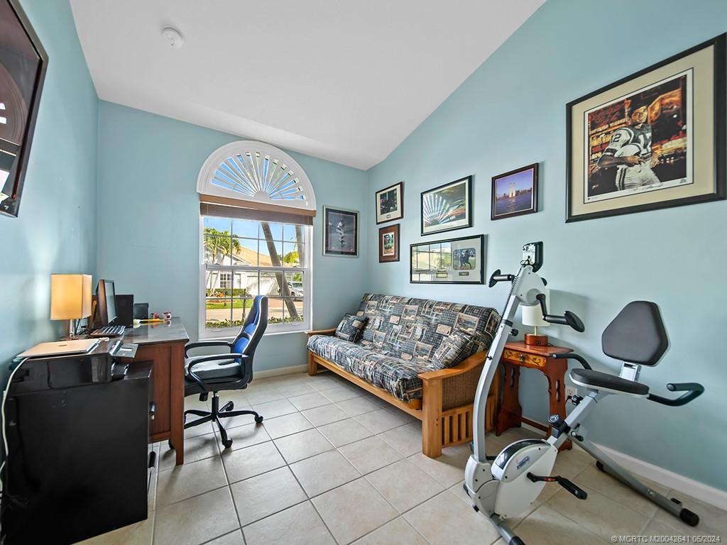 570 Northwest Red Pine Way Jensen Beach, FL 34957 - Photo 15 of 19 a bedroom with workspace a couch and a window