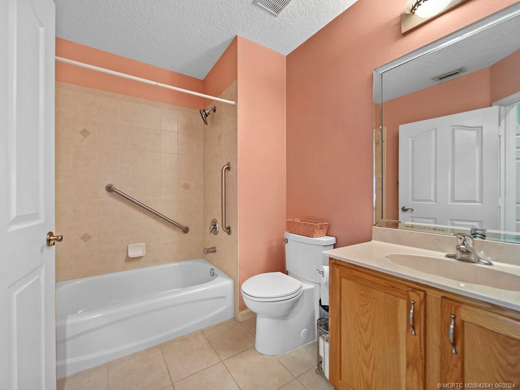570 Northwest Red Pine Way Jensen Beach, FL 34957 - Photo 16 of 19 a bathroom with a sink a toilet and a bathtub