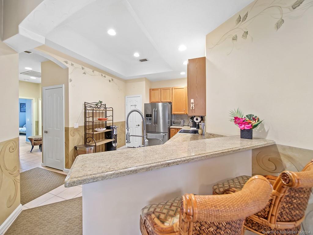570 Northwest Red Pine Way Jensen Beach, FL 34957 - Photo 4 of 19 a kitchen with granite countertop a sink and white cabinets