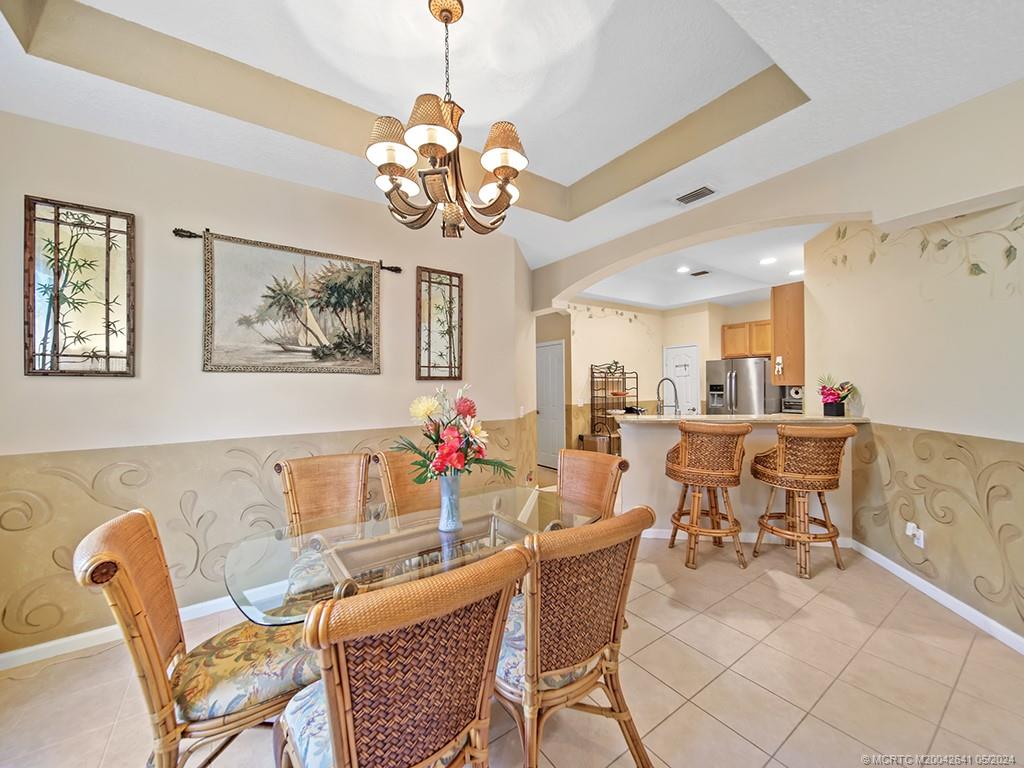 570 Northwest Red Pine Way Jensen Beach, FL 34957 - Photo 6 of 19 a view of a dining room with furniture and chandelier