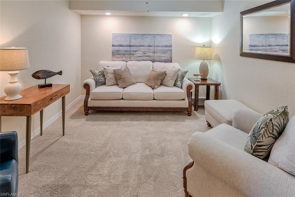 9528 Avellino Way, Unit 2515 Naples, FL 34113 - Photo 12 of 35 a living room with furniture and a lamp