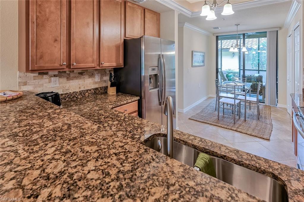 9528 Avellino Way, Unit 2515 Naples, FL 34113 - Photo 10 of 35 a kitchen with a refrigerator and a stove top oven